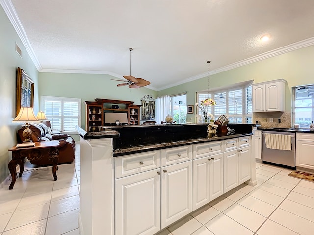 kitchen featuring white cabinetry, stainless steel dishwasher, ceiling fan, dark stone countertops, and hanging light fixtures