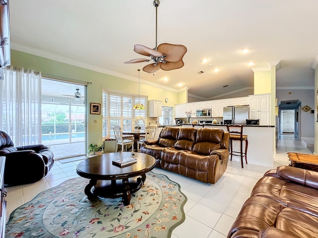 living room with ceiling fan, light tile patterned flooring, ornamental molding, and vaulted ceiling