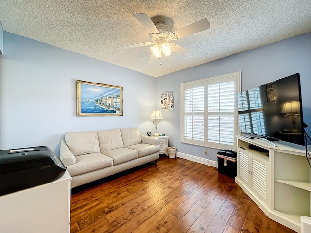 living room with ceiling fan, a textured ceiling, and hardwood / wood-style floors