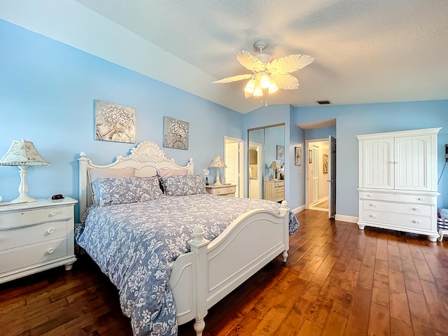 bedroom featuring a textured ceiling, ceiling fan, dark hardwood / wood-style flooring, and lofted ceiling