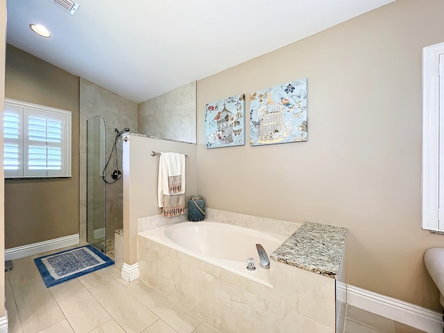 bathroom with tile patterned flooring and separate shower and tub