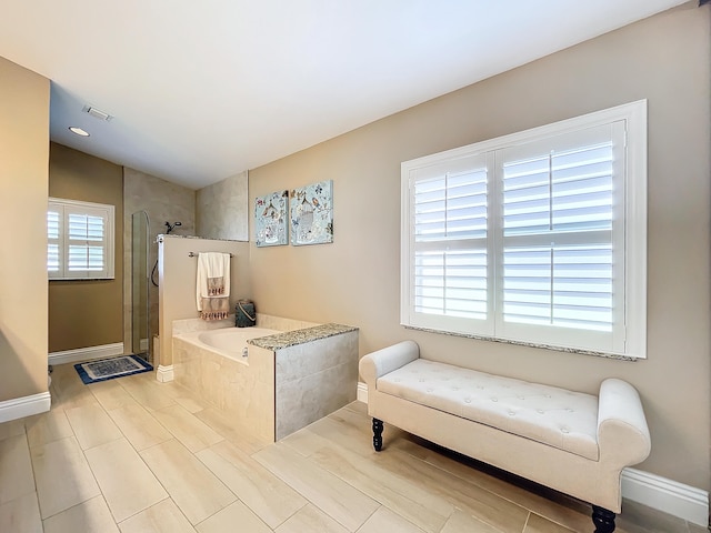 interior space with lofted ceiling, separate shower and tub, and a healthy amount of sunlight