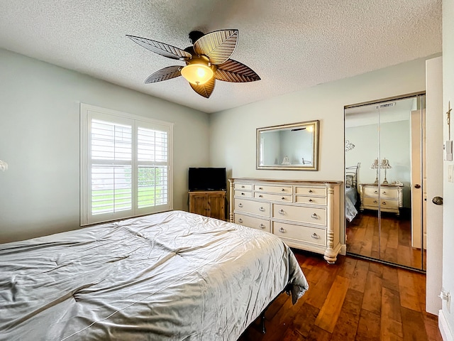 bedroom featuring a textured ceiling, a closet, ceiling fan, and dark hardwood / wood-style flooring