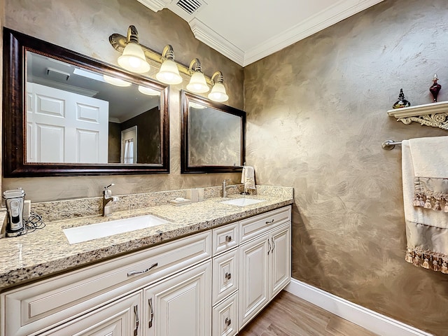 bathroom featuring hardwood / wood-style floors, ornamental molding, and vanity