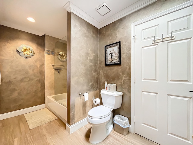 bathroom featuring ornamental molding, tiled shower / bath, hardwood / wood-style floors, and toilet