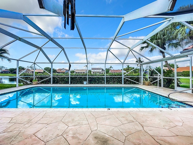 view of pool featuring glass enclosure and a patio