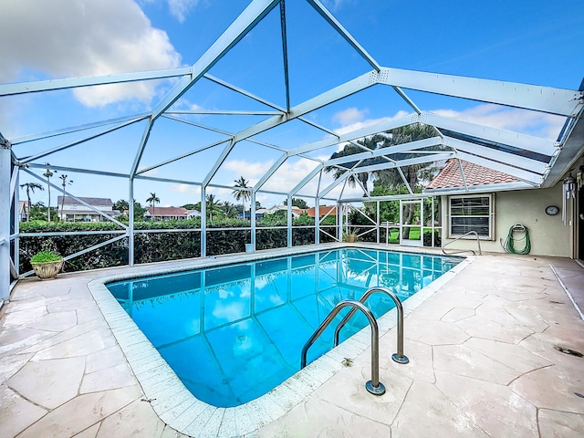 view of swimming pool with glass enclosure and a patio area