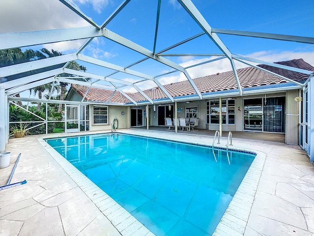 view of swimming pool featuring glass enclosure and a patio area