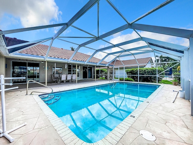 view of swimming pool featuring a patio area and a lanai