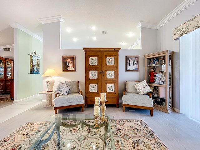 sitting room with light hardwood / wood-style flooring and crown molding