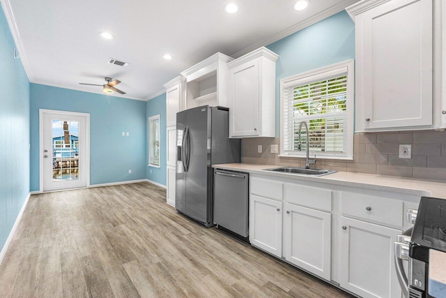 kitchen featuring a healthy amount of sunlight, ceiling fan, sink, and white cabinetry