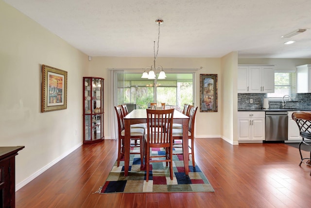 dining area featuring a chandelier, a textured ceiling, dark hardwood / wood-style floors, and sink