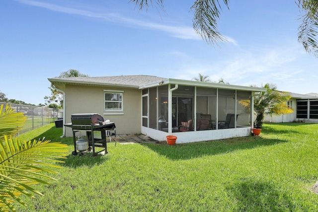 rear view of property with a yard and a sunroom