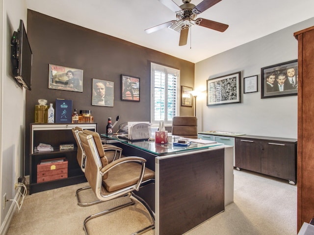 carpeted home office featuring ceiling fan