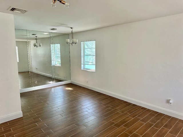 unfurnished room with a chandelier