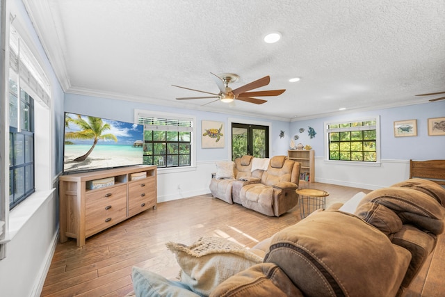 living room with crown molding, plenty of natural light, ceiling fan, and light hardwood / wood-style floors