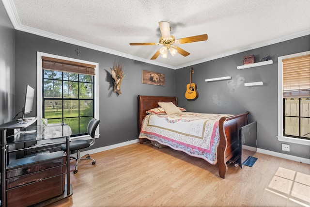 bedroom with light wood-type flooring, ceiling fan, a textured ceiling, and ornamental molding