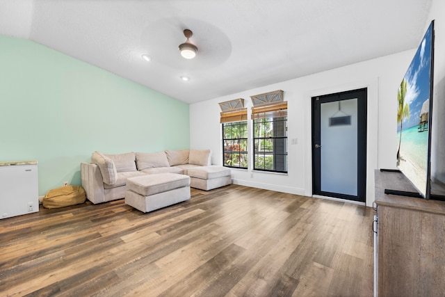 unfurnished living room featuring lofted ceiling, hardwood / wood-style floors, and ceiling fan