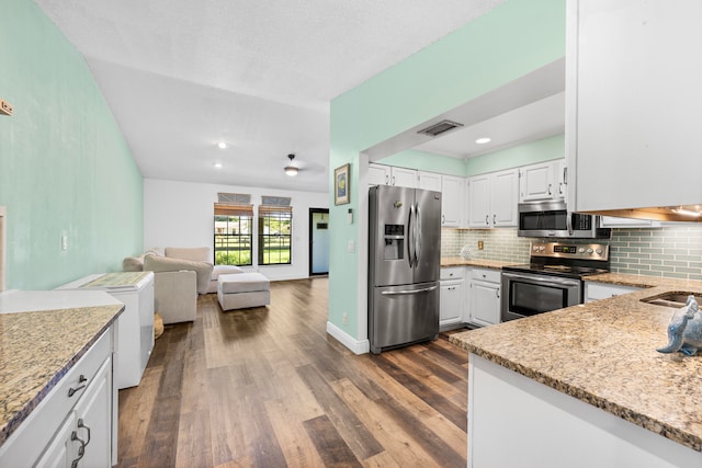 kitchen featuring dark hardwood / wood-style floors, light stone countertops, stainless steel appliances, decorative backsplash, and white cabinets