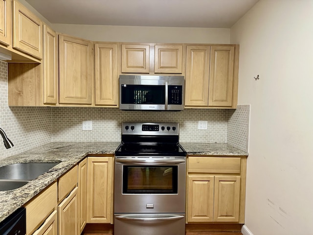 kitchen with appliances with stainless steel finishes, sink, backsplash, light stone countertops, and light brown cabinets