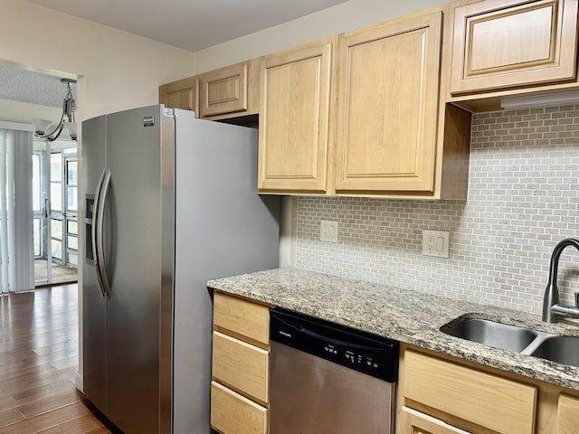 kitchen featuring stainless steel appliances, sink, light stone counters, and light brown cabinetry