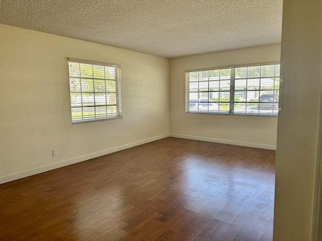 spare room with dark wood-type flooring and a textured ceiling