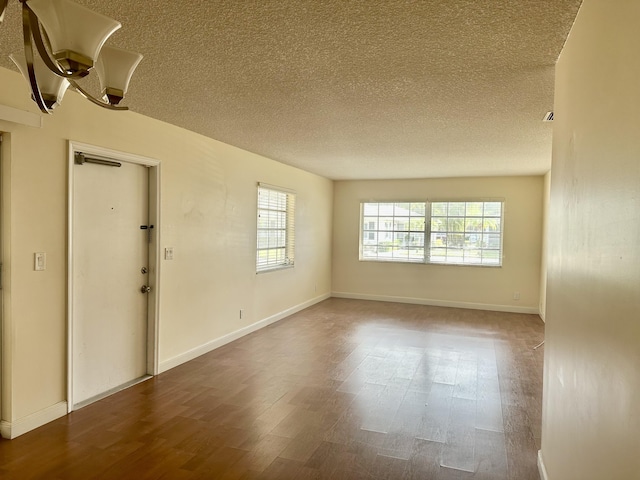 empty room featuring hardwood / wood-style flooring, a healthy amount of sunlight, and a textured ceiling