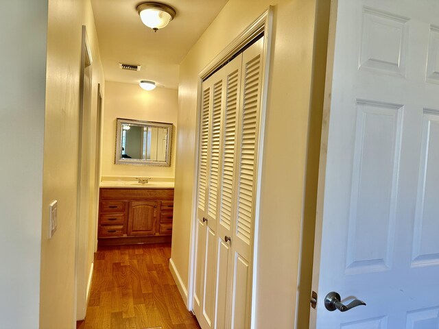 hallway with sink and light hardwood / wood-style floors