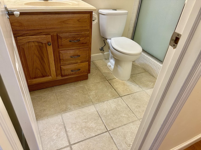 bathroom with vanity, toilet, and a shower with door