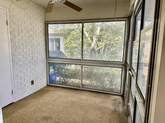 unfurnished sunroom featuring ceiling fan