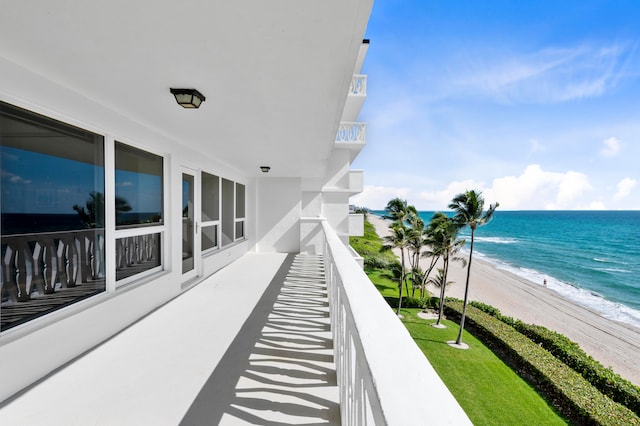 balcony featuring a beach view and a water view