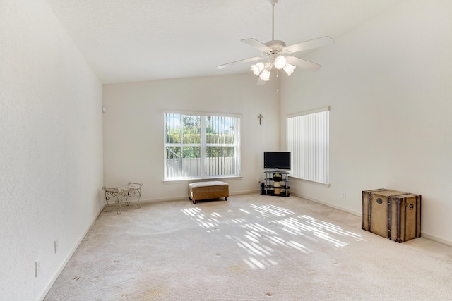 unfurnished living room with ceiling fan, light colored carpet, and lofted ceiling