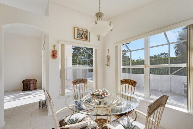 dining room with plenty of natural light, light tile patterned floors, and vaulted ceiling