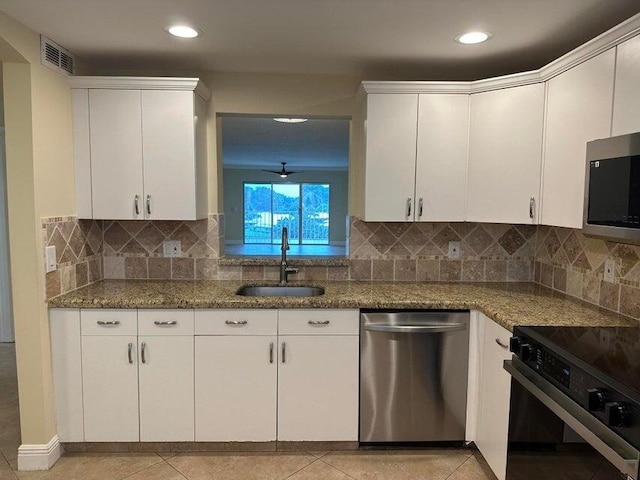 kitchen with appliances with stainless steel finishes, sink, and decorative backsplash