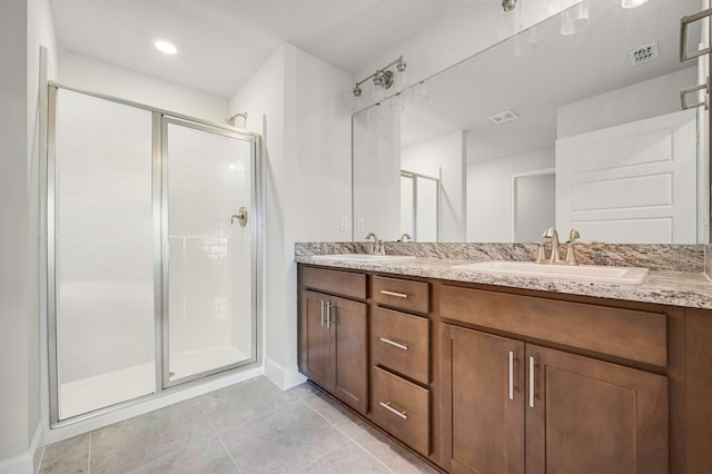 bathroom with tile patterned flooring, vanity, and a shower with door