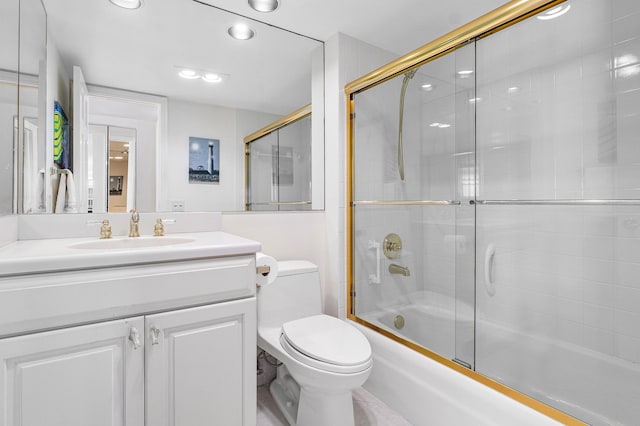 full bathroom with shower / bath combination with glass door, vanity, and toilet