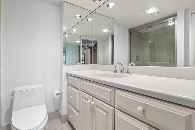 bathroom featuring tile patterned flooring, vanity, toilet, and a shower with door