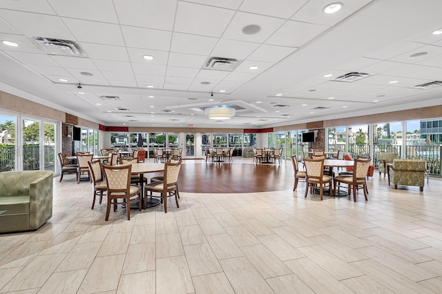 dining room featuring a drop ceiling and light hardwood / wood-style flooring