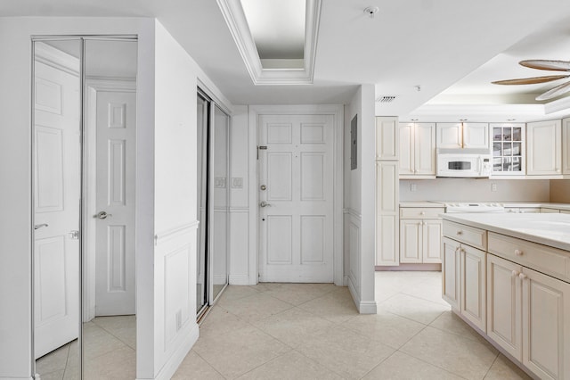 kitchen featuring ornamental molding, a tray ceiling, ceiling fan, light tile patterned floors, and electric panel