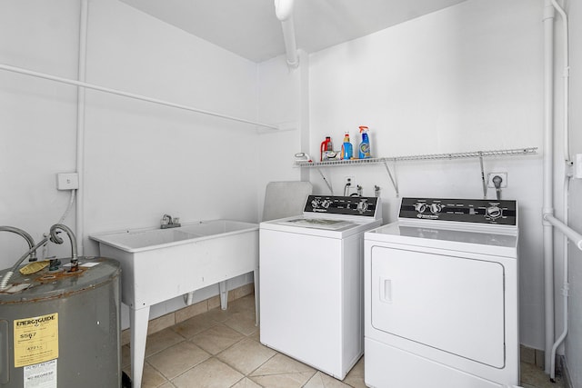 washroom with washer and dryer, electric water heater, sink, and light tile patterned floors