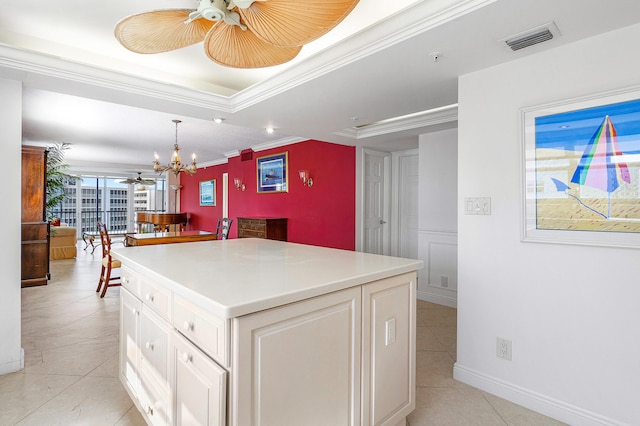 kitchen featuring white cabinetry, a center island, crown molding, pendant lighting, and ceiling fan with notable chandelier