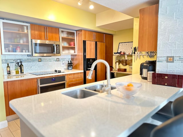 kitchen with stainless steel appliances, sink, and tasteful backsplash