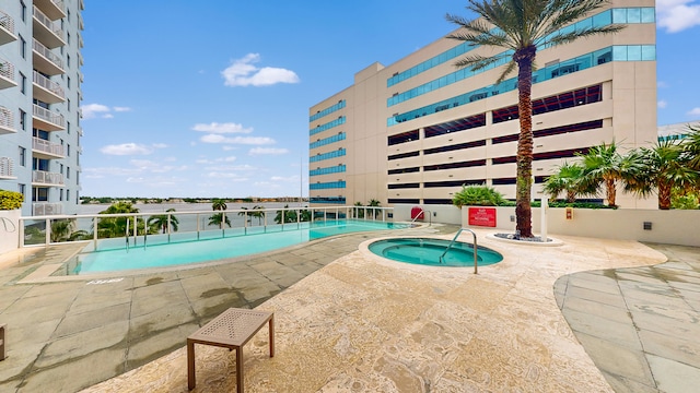 view of swimming pool featuring a community hot tub and a patio