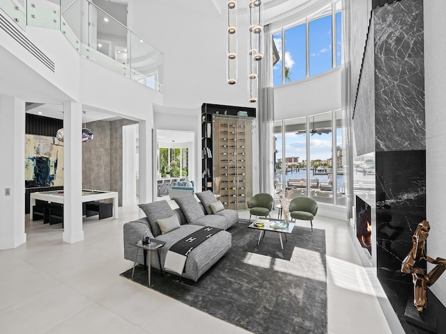 tiled living area featuring a fireplace and a towering ceiling