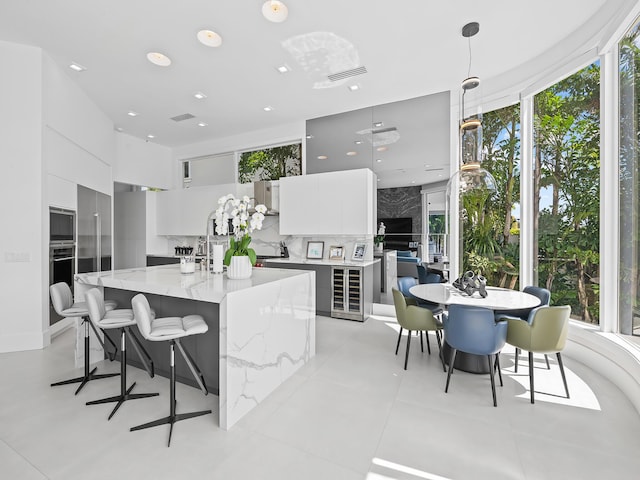 kitchen featuring stainless steel appliances, visible vents, white cabinets, decorative backsplash, and modern cabinets