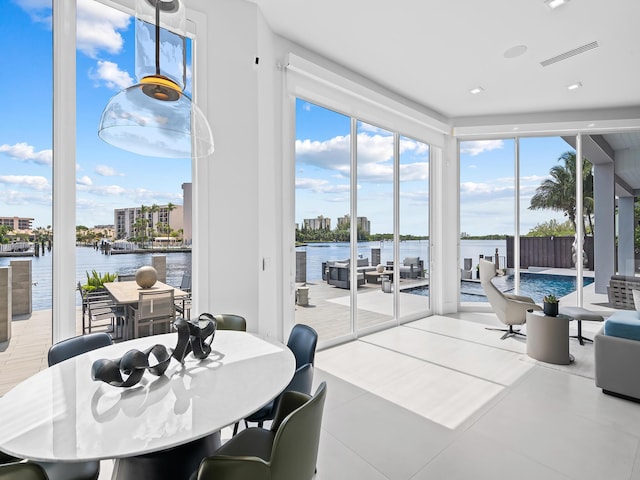 tiled dining area featuring a water view and visible vents