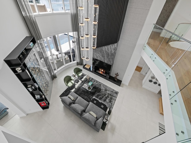 living area featuring a fireplace, a high ceiling, and tile patterned floors