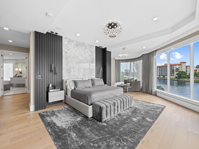 bedroom with visible vents, a water view, light wood-style flooring, and recessed lighting