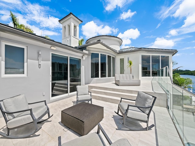 exterior space with metal roof, outdoor lounge area, stucco siding, a standing seam roof, and a patio area