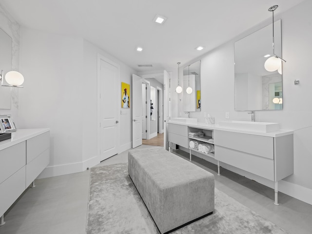 full bathroom featuring double vanity, baseboards, a sink, and recessed lighting